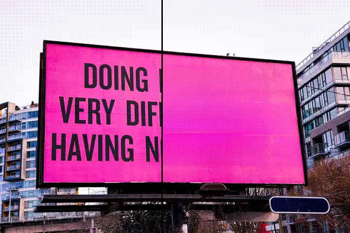 Pink billboard displays partial black text: 'DOING VERY DIFFI HAVING N' against city buildings.